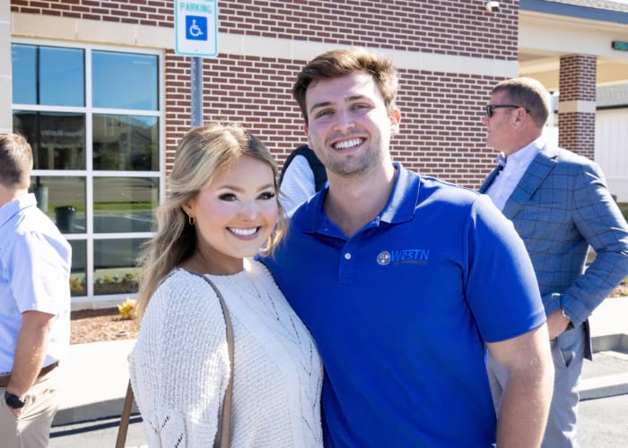 Male and Female nicely dressed smiling at the camera