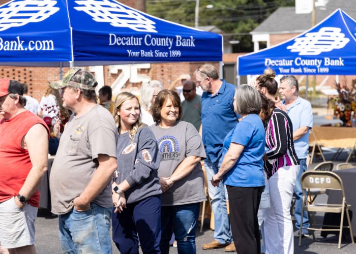group of people in line in front of Decatur County Bank tents