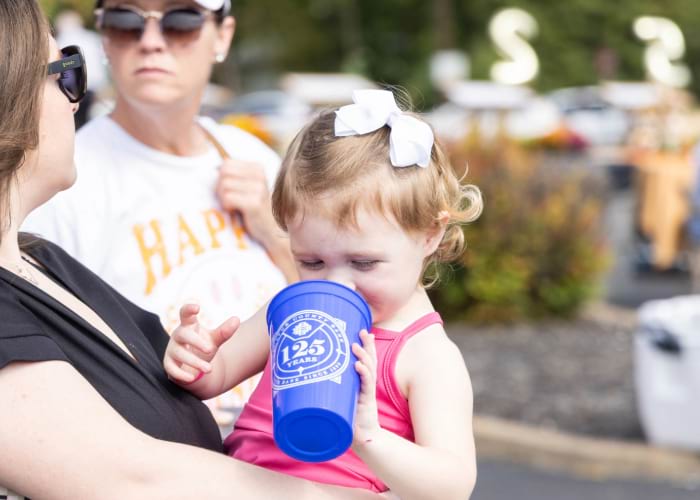little girl drinking out of blue cup