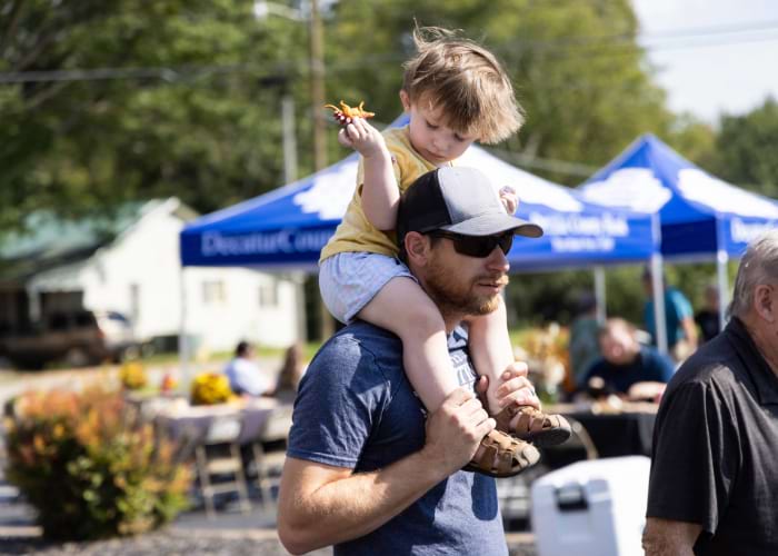 kid being held on man's shoulders