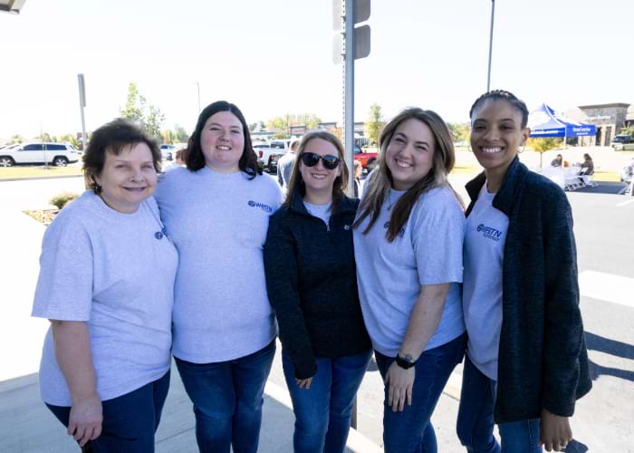 group of women wearing West Tennessee bank shirts smiling at the camera
