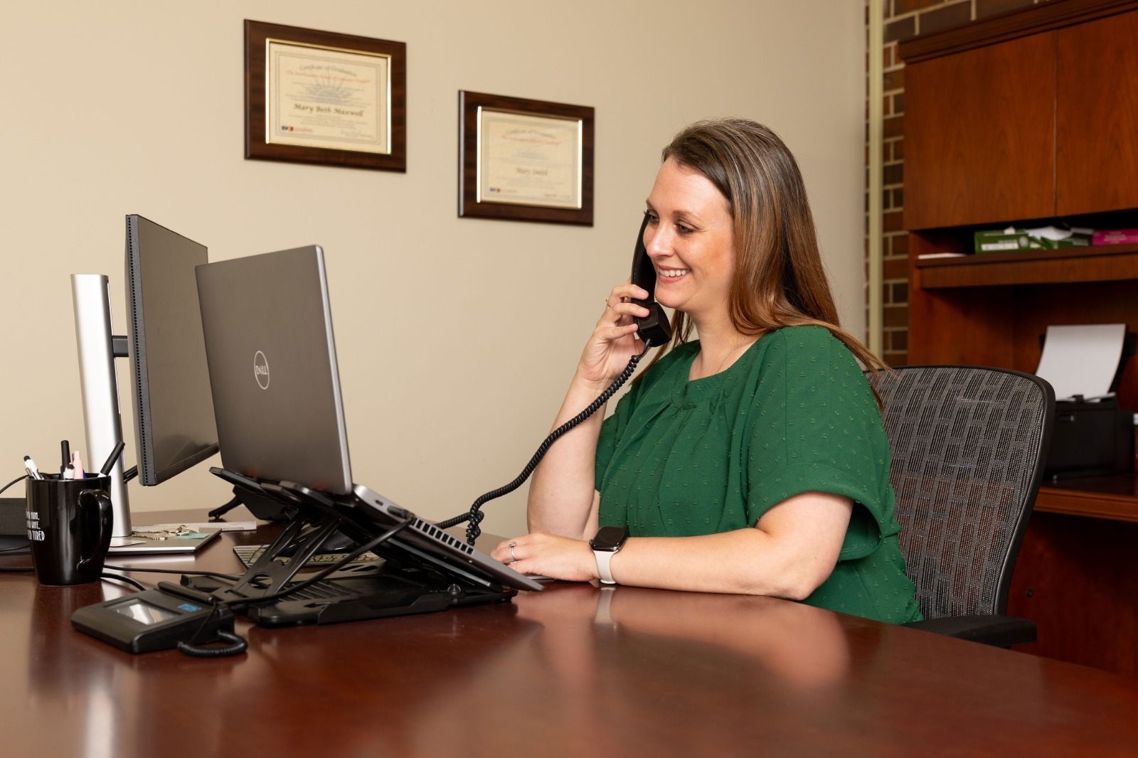 woman sitting at desk talking on the phone