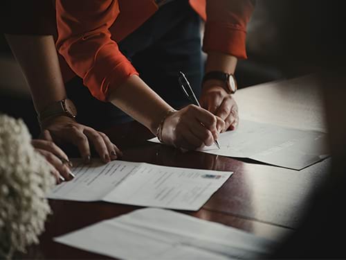 A couple looks over a document while the man signs it