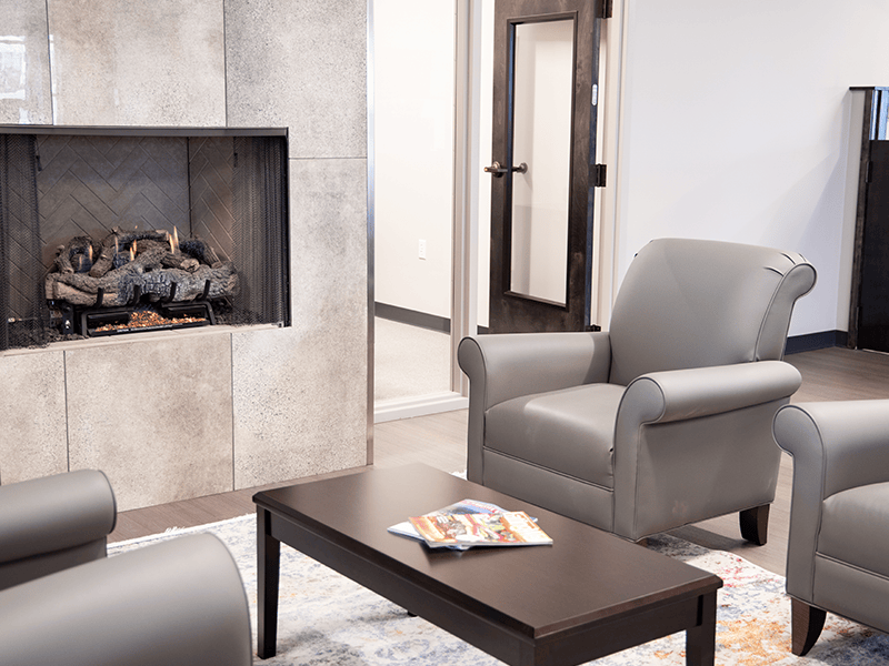 A couple of plush chairs in front of a fireplace