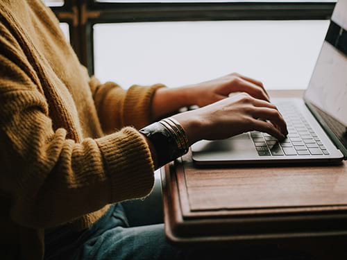 hands typing on laptop