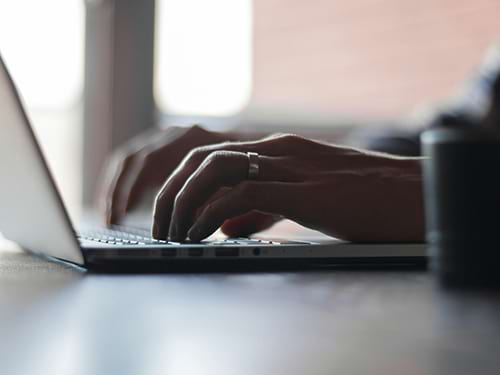 hands typing on computer