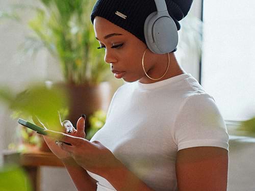 woman with headphones scrolling on phone