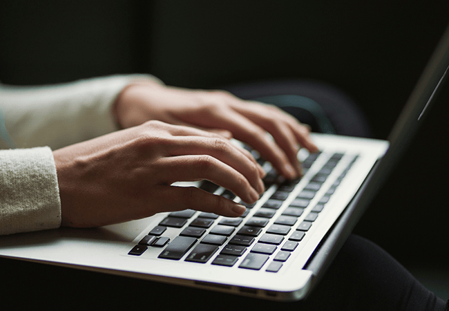 hands typing on laptop